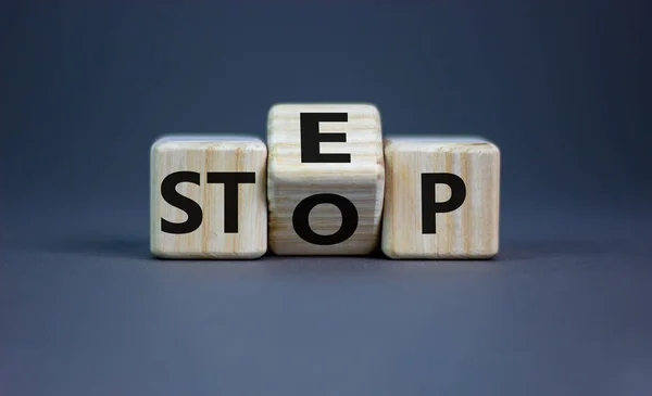 Stop or next step symbol. Turned cubes and changed the word \'stop\' to \'step\'. Beautiful grey background, copy space. Business, stop or next step concept.