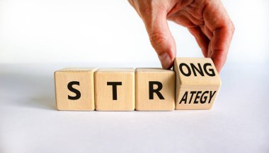 Güçlü strateji sembolü. İş adamı 'güçlü strateji' sözleriyle tahta küpü çevirir. Güzel beyaz arka plan, kopyalama alanı. İş ve güçlü strateji kavramı.