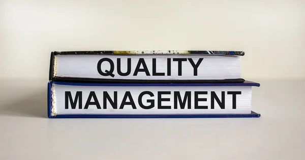 Quality management symbol. Concept words \'Quality management\' on books on a beautiful white table, white background. Business and quality management concept.