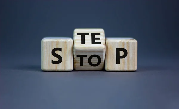 Stop or next step symbol. Turned cubes and changed the word \'stop\' to \'step\'. Beautiful grey background, copy space. Business, stop or next step concept.