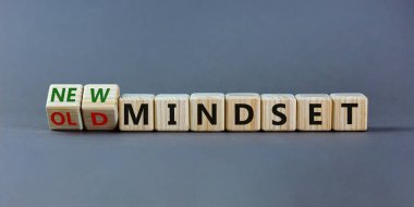 Yeni vs eski zihniyet sembolü. Tahta küpü döndürdü ve 'eski zihniyet' kelimesini 'yeni zihniyet' olarak değiştirdi. Güzel gri arkaplan. İş, yeni ya da eski düşünce tarzı. Boşluğu kopyala.