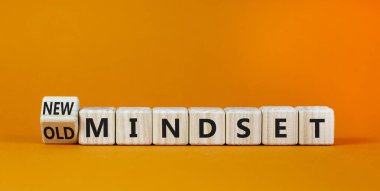 Yeni vs eski zihniyet sembolü. Tahta küpü döndürdü ve 'eski zihniyet' kelimesini 'yeni zihniyet' olarak değiştirdi. Güzel turuncu arka plan. İş, yeni ya da eski düşünce tarzı. Boşluğu kopyala.