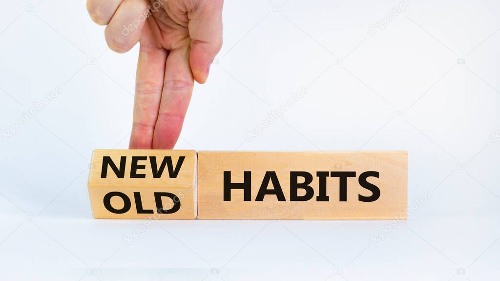 New habits symbol. Businessman turns a wooden block and changes words 'old habits' to 'new habits'. Beautiful white background. Business, psychological and new or old habits concept. Copy space.
