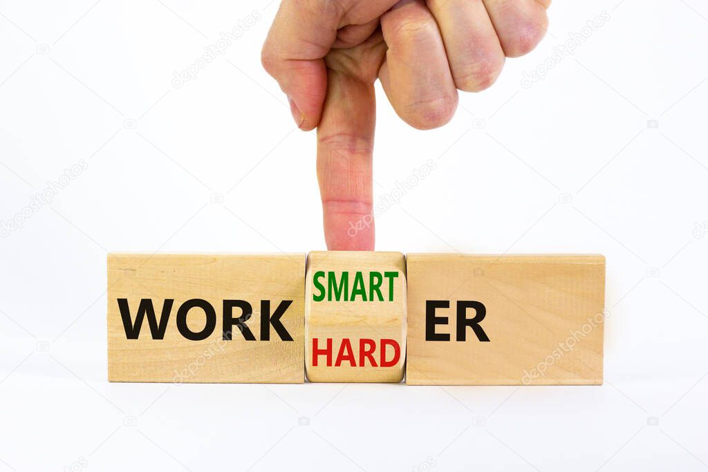 Work harder or smarter symbol. Businessman turns wooden block and changes words 'work harder' to 'work smarter'. Beautiful white background, copy space. Business and work harder or smarter concept.