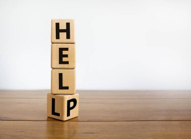 Cehennem ya da yardım sembolü. Küpü çevirdim ve 'cehennem' kelimesini 'yardım' olarak değiştirdim. İş, psikoloji ve cehennem ya da yardım kavramı. Güzel ahşap masa, beyaz arkaplan, kopyalama alanı.