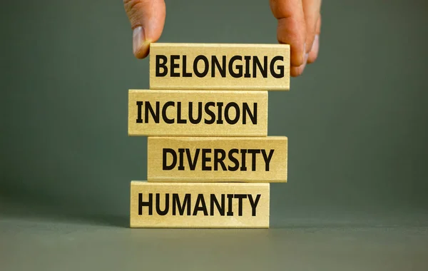 Humanity, diversity, inclusion, belonging symbol. Wooden blocks with words humanity, diversity, inclusion, belonging on beautiful grey background. Diversity, humanity, inclusion, belonging concept.