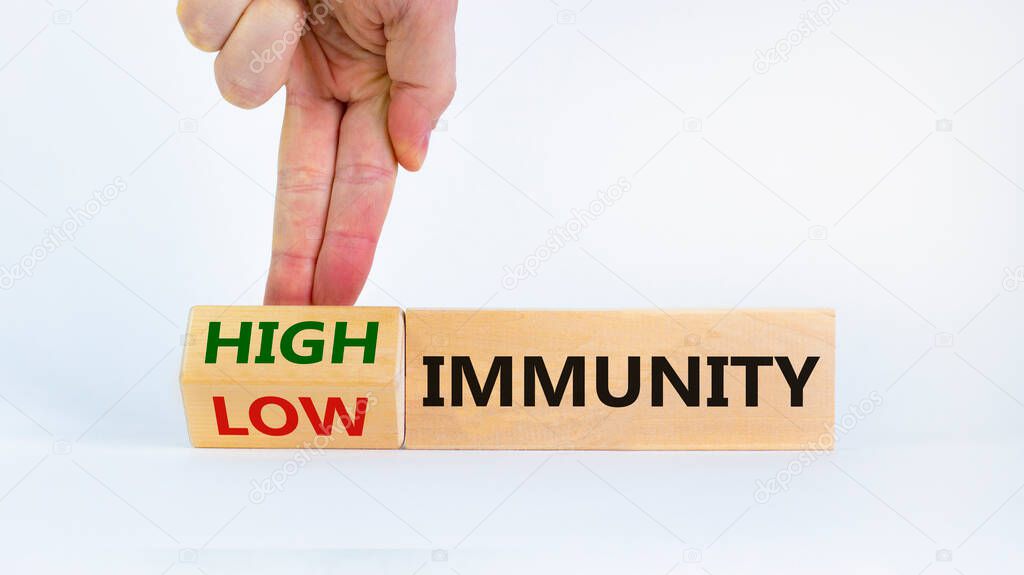 High or low immunity symbol. Doctor turns a block and changes words 'low immunity' to 'high immunity'. Beautiful white background. Medical, high or low immunity concept. Copy space.
