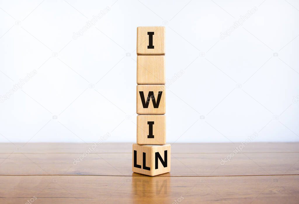 I will win symbol. Turned a wooden cube and changed words i will to i win. Beautiful wooden table, white background, copy space. Business, motivational and i will win concept.
