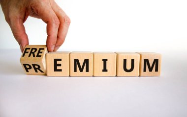 Premium ya da Freemium sembolü. İşadamı ahşap küpü çeviriyor ve 'premium' kelimesini 'freemium' olarak değiştiriyor. Güzel beyaz arka plan. İş, prim ya da özgürlük konsepti. Boşluğu kopyala.