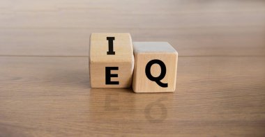IQ or EQ symbol. Turned a cube and changed the expression 'IQ - intelligence quotient' to 'EQ - emotional quotient'. Beautiful wooden background. Psychological, business IQ or EQ concept. Copy space.