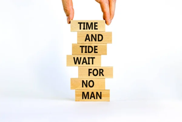 Time to action symbol. Wooden blocks with words time and tide wait for no man. Beautiful white background. Businessman hand. Business and time to action concept. Copy space.