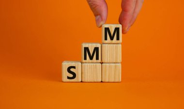 SMM, sosyal medya pazarlama sembolü. 'SMM' li tahta küpler - güzel turuncu arka planda sosyal medya pazarlaması, kopyalama alanı. İşadamı eli. İş dünyası, SMM - sosyal medya pazarlama kavramı.