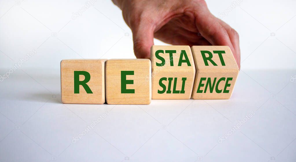 Restart and resilience symbol. Businessman turns cubes and changes the word 'restart' to 'resilience'. Beautiful white background. Business and restart - resilience concept. Copy space.