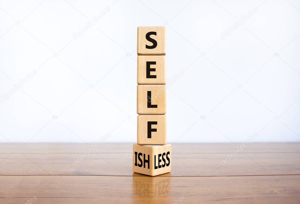 Selfish or selfless symbol. Turned cubes and changed the word 'selfish' to 'selfless'. Beautiful white background, copy space. Business, psuchological and selfish or selfless concept.