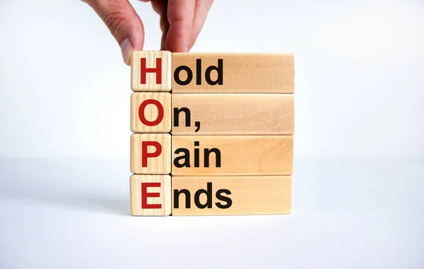 HOPE, hold on, pain ends symbol. Wooden cubes with words \'HOPE, hold on, pain ends. Beautiful white background, copy space. Business, motivational and HOPE, hold on, pain ends concept.