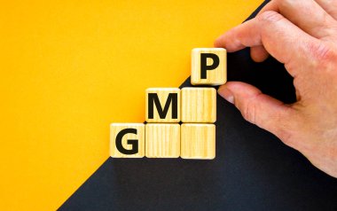 GMP, good manufacturing practice symbol. Concept words GMP, good manufacturing practice on cubes on a beautiful yellow background. Business and GMP, good manufacturing practice concept. Copy space.