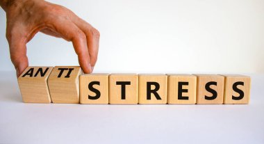 Strese karşı stres sembolü. Doktor küpleri döndürür ve stresi anti-strese çevirir. Güzel beyaz masa, beyaz arka plan. Tıbbi, psikolojik, strese karşı stres konsepti. Boşluğu kopyala.
