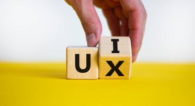 UX ya da UI sembolü. İşadamı bir küp çevirir ve UX kelimesini, kullanıcı deneyimini UI, kullanıcı arayüzü olarak değiştirir. Güzel beyaz arka plan. İş, UI kullanıcı deneyimi veya kullanıcı arayüzü kavramı. Boşluğu kopyala.
