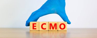 ECMO symbol. Concept words 'ECMO, Extra Corporeal Membrane Oxygenation' on cubes on a beautiful white background. Doctor hand in blue glove. Copy space. Medical, ECMO concept. clipart