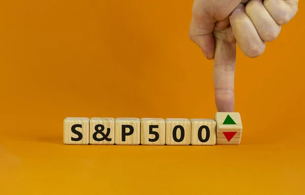 S ve P 500 sembolü. İşadamı bir küp çevirir ve S ve P500 endeksinin eğilimi değiştirdiğini ve düşmek yerine yükseldiğini sembolize eden bir okun yönünü değiştirir. İş, S ve P500 kavramı.