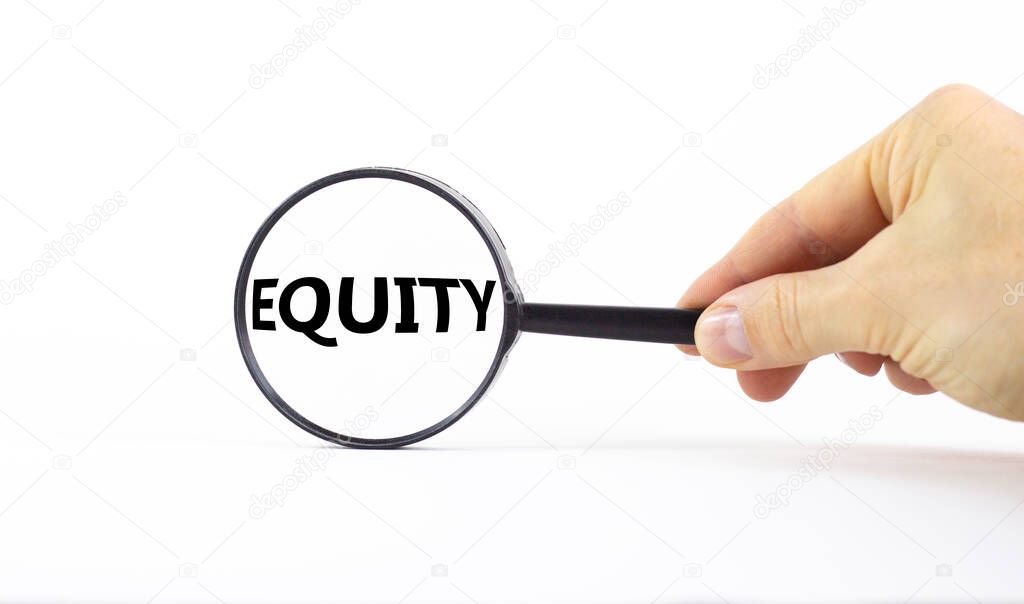 Equity and inclusion symbol. Magnifying glass with word equity on a beautiful white background. Businessman hand. Business, equity and inclusion concept, copy space.