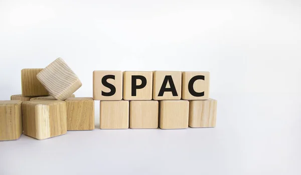 SPAC, special purpose acquisition company symbol. Wooden cubes with word \'SPAC\' on beautiful white background, copy space. Business and SPAC, special purpose acquisition company concept.