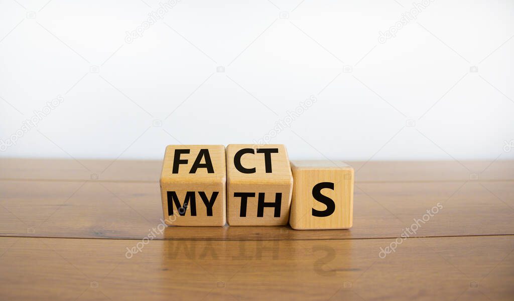 Facts or myths symbol. Turned cubes and changed the word 'myths' to 'facts'. Beautiful wooden table, white background, copy space. Business and facts or myths concept.