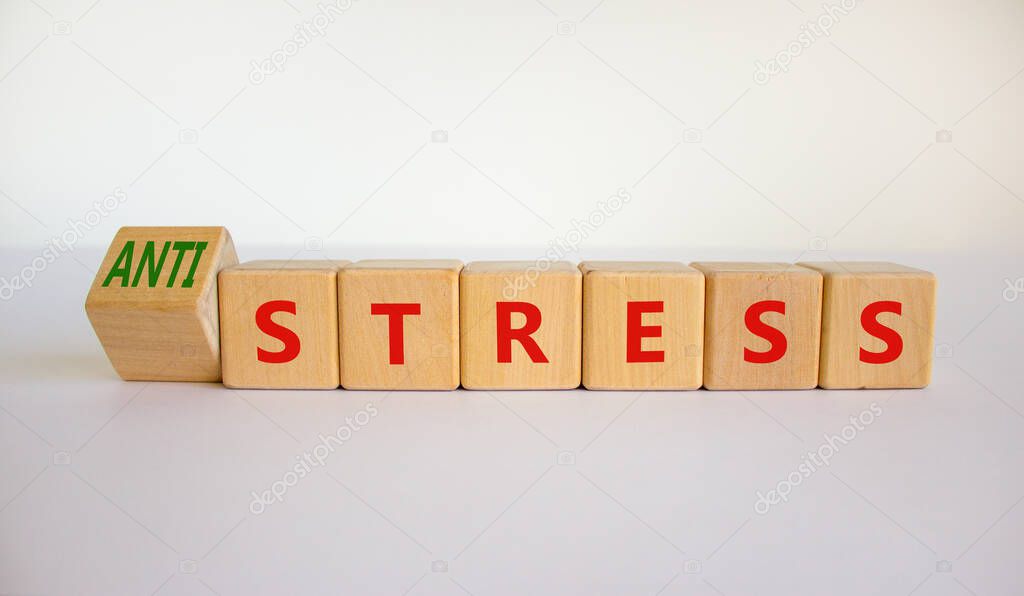 Antistress vs stress symbol. Turned cubes and changed the word stress to anti stress. Beautiful white table, white background. Medical, psychological, antistress vs stress concept. Copy space.
