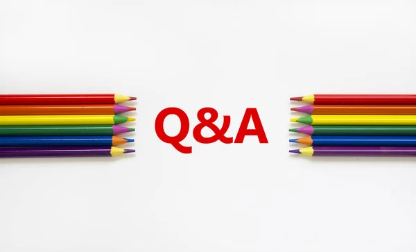 Q and A symbol. Concept word 'Q and A, questions and answers' on a beautiful white background. Colored pencils. Business and Q and A, questions and answers concept, copy space.