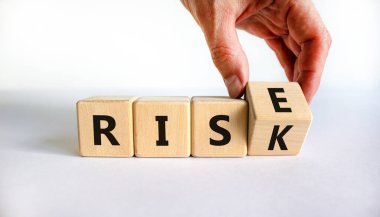 Risk yükselme sembolüne karşı. İşadamı tahta küpü dönüştürür ve yükselmek için risk kelimesini değiştirir. Güzel beyaz arka plan, kopyalama alanı. İş, risk ve yükseliş kavramı.