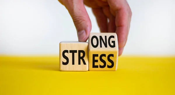 強いストレスシンボル ビジネスマンは 強いストレス という言葉で木製の立方体を回します 美しい黄色のテーブル 白い背景 コピースペース ビジネスと強いストレスコンセプト — ストック写真