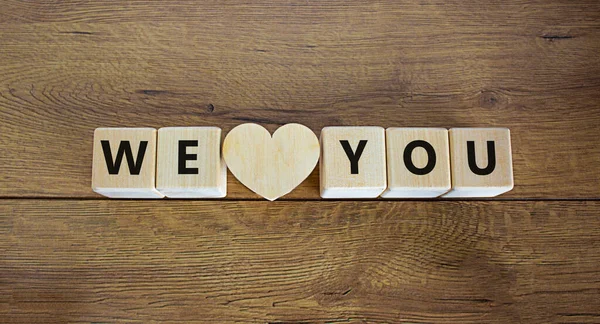 We love you symbol. Wooden cubes and wooden heart with words 'I love you'. Beautiful wooden background, copy space. We love you concept.