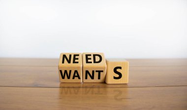 Sembol istiyor ya da ihtiyacı var. Küplere dönüştü ve 'istekler' kelimesini 'ihtiyaçlar' a çevirdi. Güzel ahşap masa, beyaz arka plan, fotokopi alanı. Sevgililer Günü ve konsept istiyor ya da ihtiyacı var.