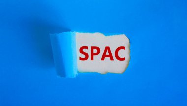 SPAC, özel amaçlı şirket sembolü. Yırtık mavi kağıdın arkasında 'SPAC' kelimeleri beliriyor. Güzel mavi arkaplan, kopyalama alanı. İş ve SPAC, özel amaçlı satın alma şirketi kavramı.