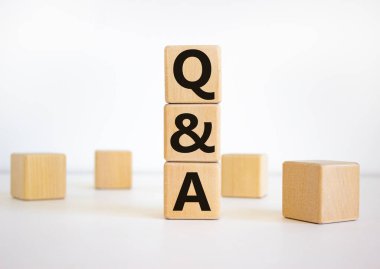 Sorular ve cevaplar sembolü. Tahta küplerdeki güzel beyaz arka planda soru ve cevaplara 