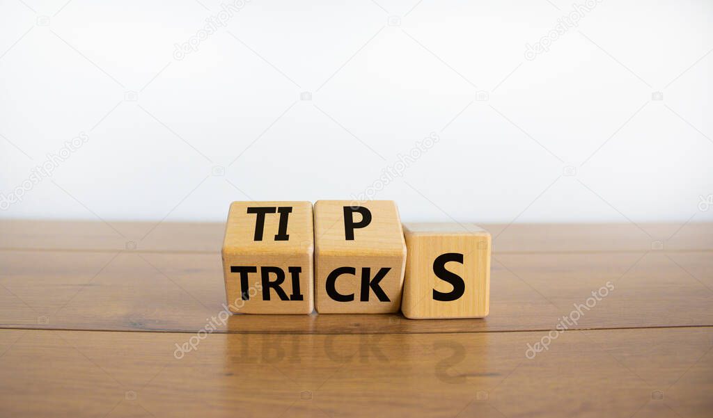 Tips and tricks symbol. Tured cubes and changed the word 'tricks' to 'tips'. Beautiful wooden table, white background. Business, tips and tricks concept. Copy space.