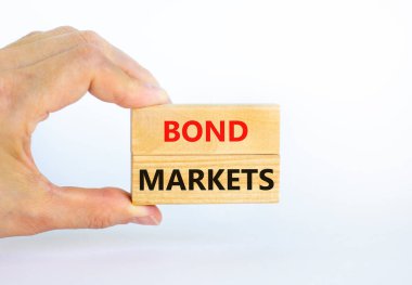 Tahvil piyasası sembolü. Güzel beyaz arka planda 'Bond marketleri' yazan tahta bloklar, kopyalama alanı. İşadamı eli. İş ve tahvil piyasaları kavramı.