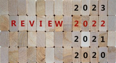 İş konsepti gözden geçirme 2022. Tahta küplerde 'REVIEW 2022' ve '2020, 2021, 2023 sayıları. Güzel ahşap zemin, kopyalama alanı. İş, 2022 gözden geçirme kavramı.