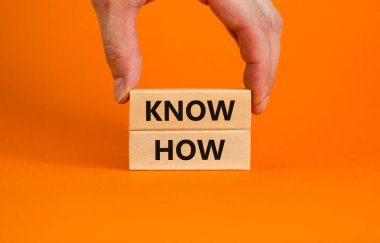 Nasıl bir sembol olduğunu biliyorum. Güzel turuncu arka planda 'Nasıl yapılacağını bil' yazan tahta bloklar, kopyalama alanı. İşadamı eli. İş, yenilik ve konsepti bilmek.