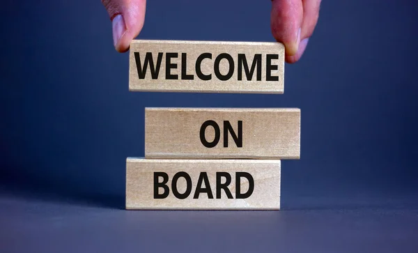 Welcome on board symbol. Wooden blocks with words 'Welcome on board'. Beautiful grey background, businessman hand. Business, welcome on board concept, copy space.