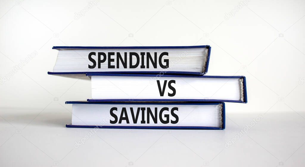 Spending vs savings strategy symbol. Books with words 'Spending vs savings'. Beautiful white background, copy space. Business, spending vs savings strategy concept.