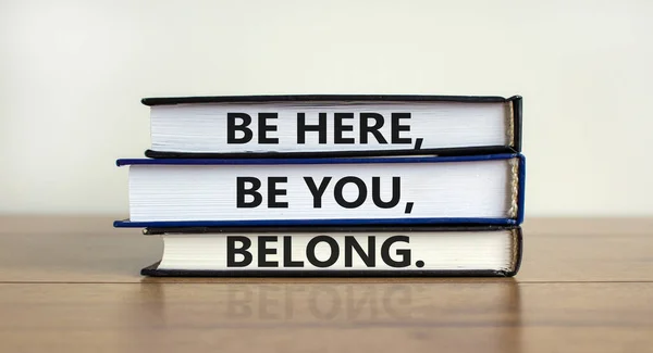Diversity, inclusion and belong symbol. Books with words \'be here, be you, belong\' on beautiful wooden table, white background. Business, diversity, inclusion and belong concept. Copy space.