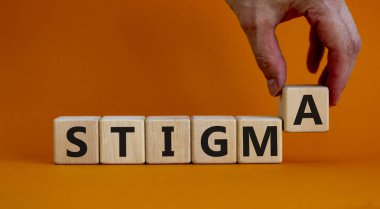 Stigma sembolü. Doktor 'damga' kelimesiyle küpleri tutuyor. Güzel turuncu arka plan. Psikolojik, tıbbi, iş ve leke konsepti. Boşluğu kopyala.