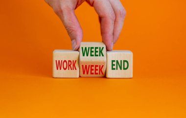 Work week or weekend symbol. Businessman turns the wooden cube and changes words 'Work week' to 'Weekend'. Beautiful orange background. Work week or weekend and business concept. Copy space.