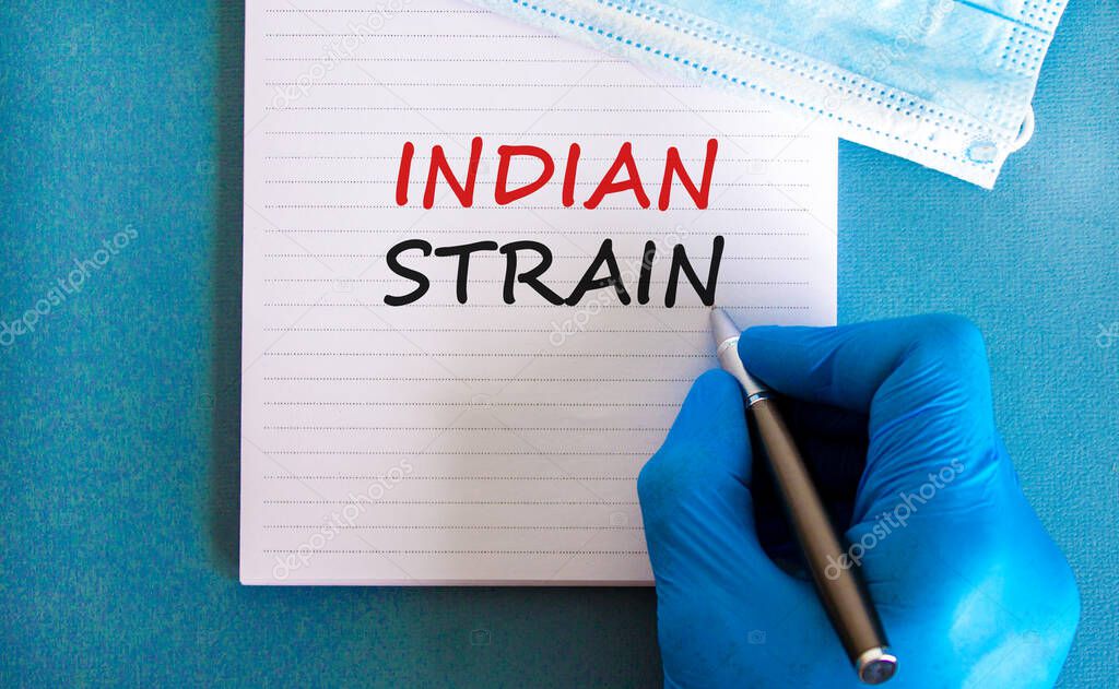 New covid-19 indian variant strain symbol. Hand in blue glove with white card. Concept words 'indian strain'. Metalic pen. Medical and COVID-19 indian variant strain concept. Copy space.