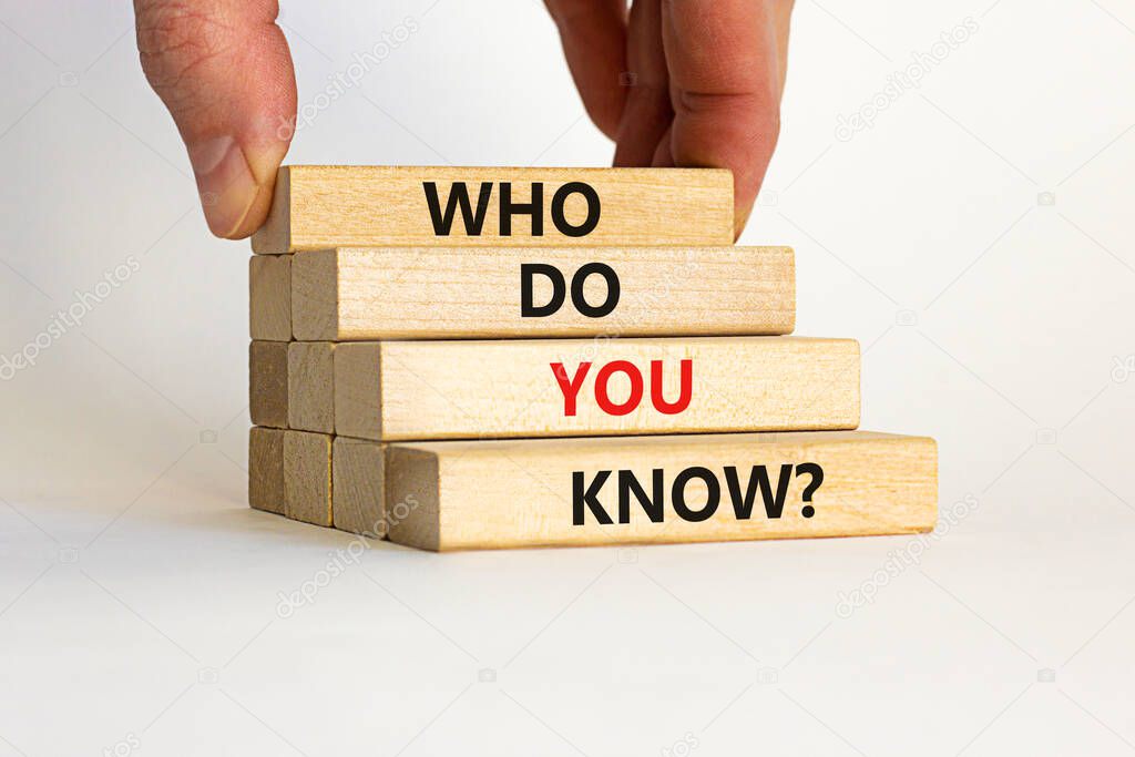 Who do you know symbol. Wooden blocks with words 'who do you know'. Beautiful white background. Businessman hand. Business and who do you know concept. Copy space.