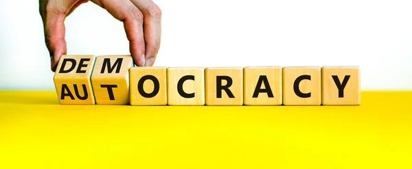 民主主義や自治のシンボル ビジネスマンは木製のキューブを回し 民主主義に単語の自律性を変更します 美しい白い背景 コピースペース ビジネスと民主主義または自治主義の概念 — ストック写真