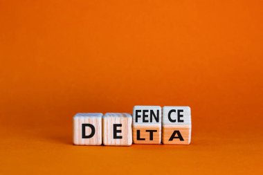 Covid-19 delta varyantı savunma sembolü. Tahta küpü döndürdü ve delta kelimesini savunmak için değiştirdi. Güzel turuncu arka plan. Covid-19 delta varyantı savunma konsepti. Boşluğu kopyala.