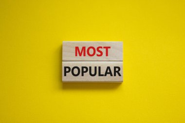 En popüler sembol. Tahta bloklardaki güzel sarı arka planda en popüler kavramsal kelimeler. Uzayı kopyala İş ve En Popüler Konsept.