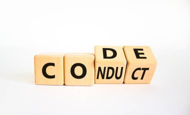 Davranış sembolü. Tahta küpü çevirdim ve şifreyi yönlendirmek için değiştirdim. Güzel beyaz arka plan. İş ve davranış kuralları konsepti. Boşluğu kopyala.